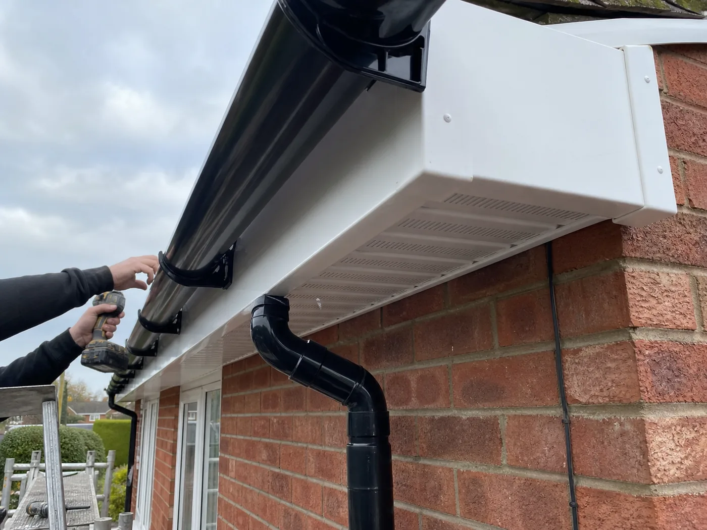 White uPVC fascia, soffit and black guttering on a brick house